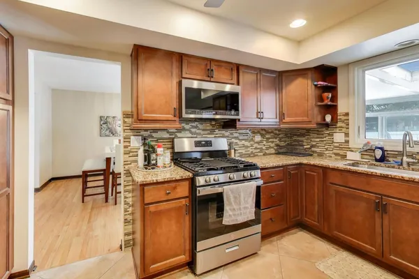 a kitchen with stainless steel appliances a stove a sink and a microwave