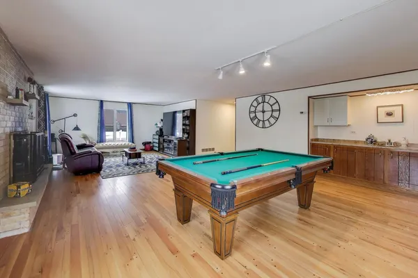 a room with furniture pool table and chairs