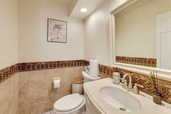 a bathroom with a sink mirror vanity and toilet