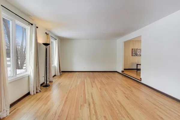 an empty room with wooden floor and a window