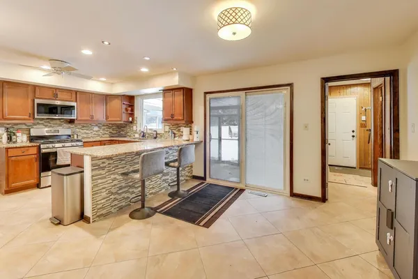 a kitchen with stainless steel appliances granite countertop a stove top oven a sink and a refrigerator