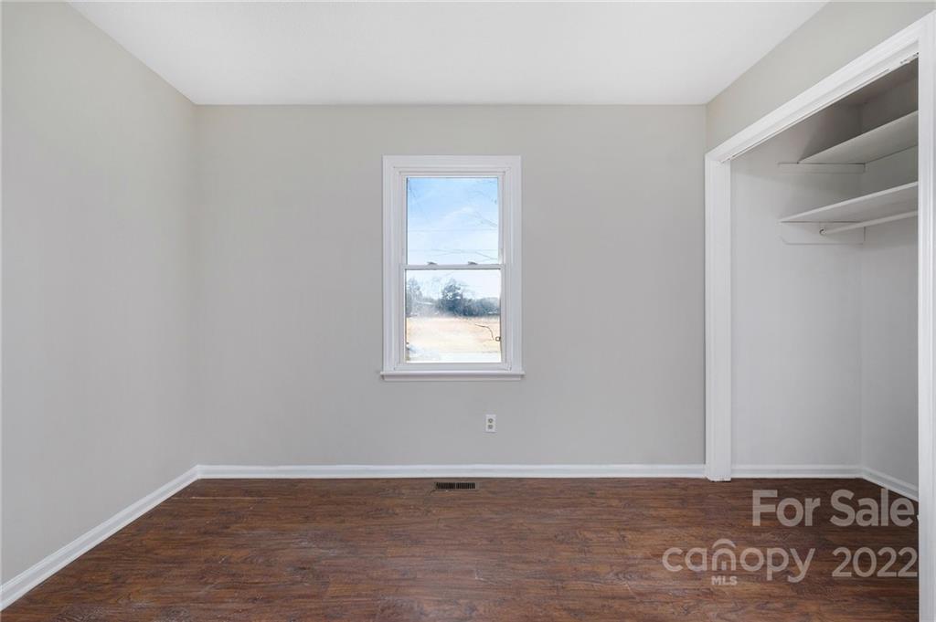 13809 Mayes Road Huntersville, NC 28078 - Photo 12 of 15 a view of an empty room with a window and wooden floor
