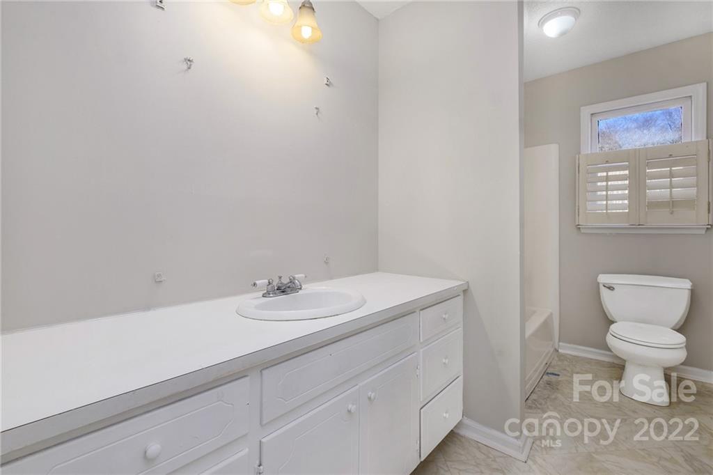 13809 Mayes Road Huntersville, NC 28078 - Photo 13 of 15 a bathroom with a sink a toilet and a mirror