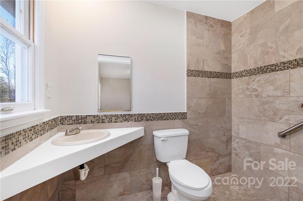 13809 Mayes Road Huntersville, NC 28078 - Photo 4 of 15 a bathroom with a sink a toilet a mirror and shower