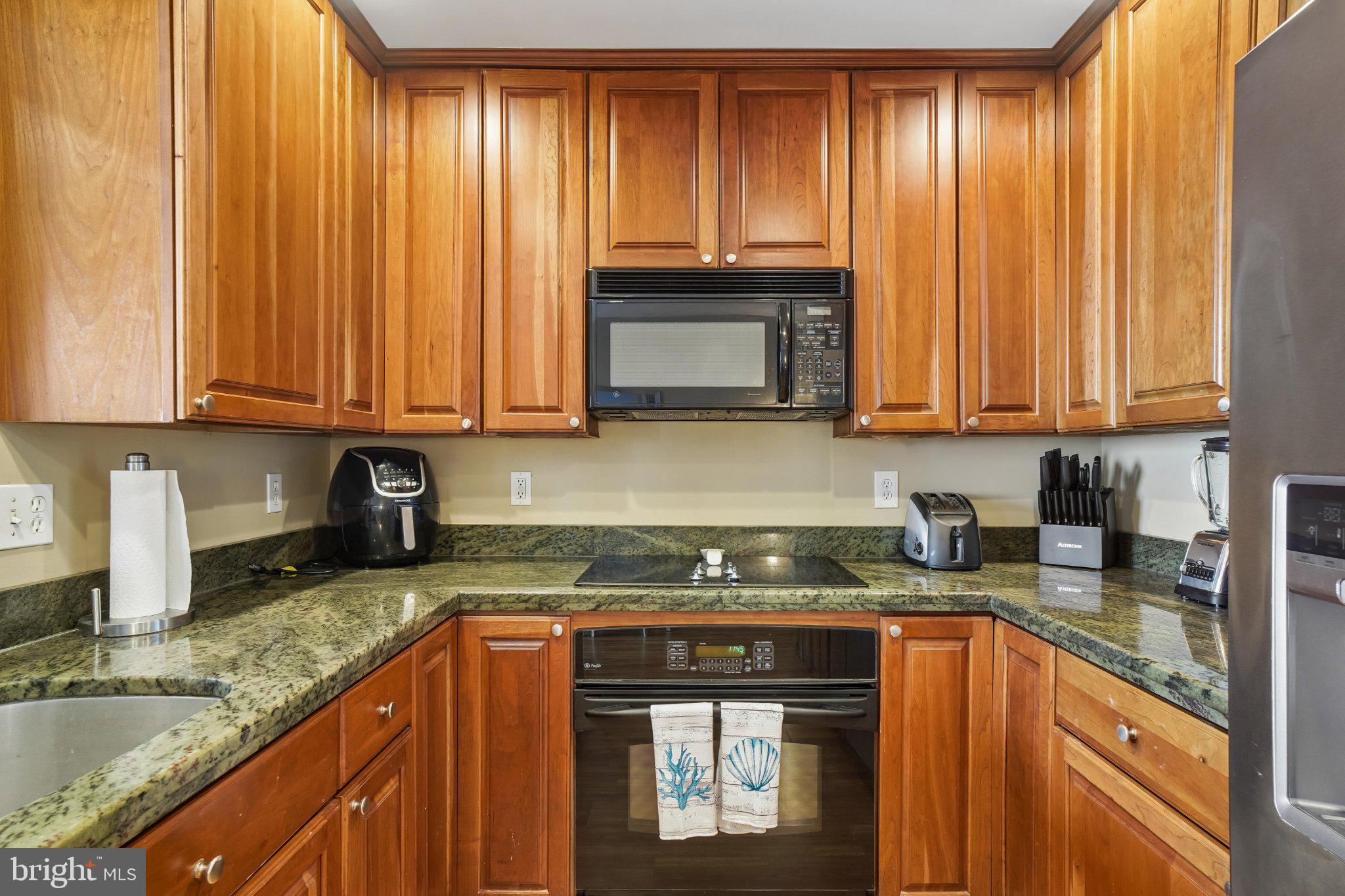 902 Chesapeake House Road, Unit 902N Bethany Beach, DE 19930 - Photo 13 of 37 Warm wood and granite kitchen elegance.