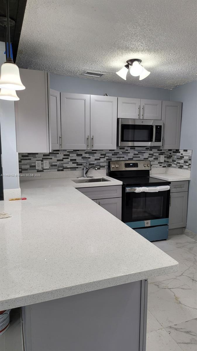 935 West 5th Street, Unit 935 Riviera Beach, FL 33404 - Photo 3 of 11 a kitchen with a stove and a sink