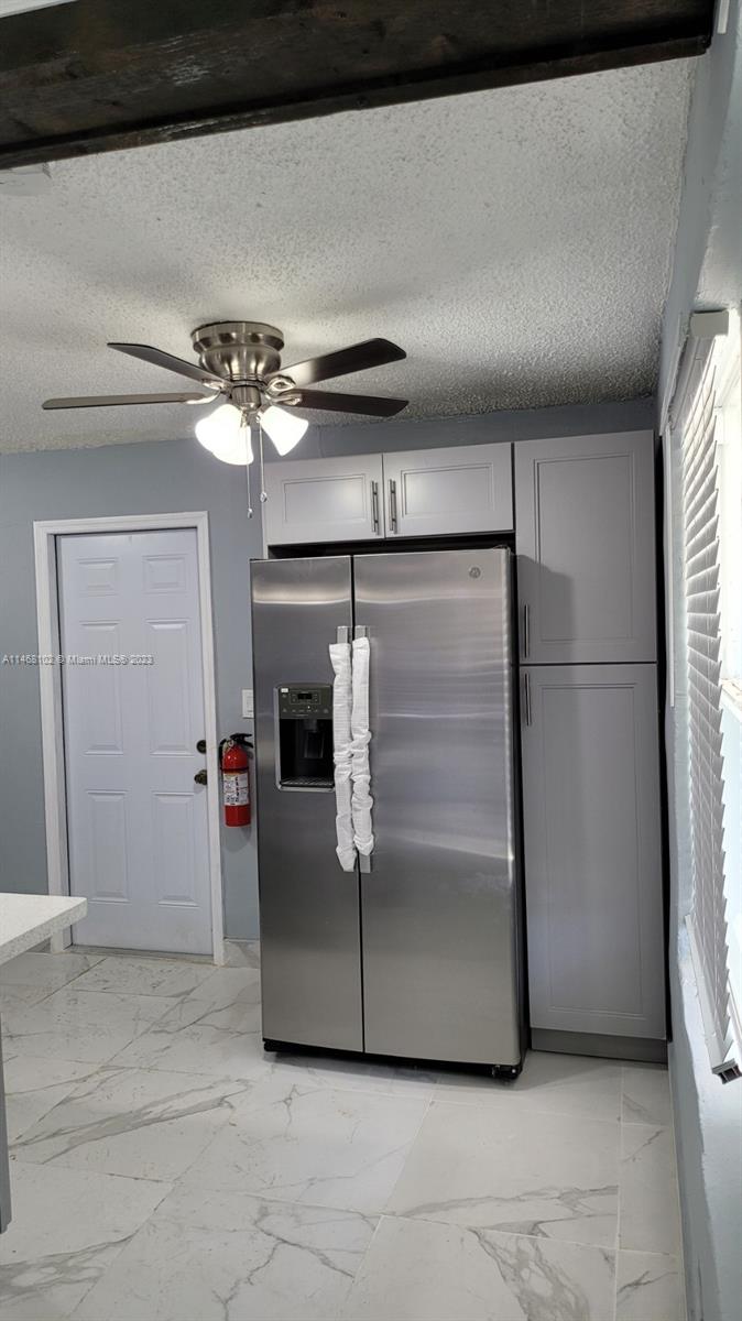 935 West 5th Street, Unit 935 Riviera Beach, FL 33404 - Photo 4 of 11 a view of a refrigerator in kitchen and an empty room