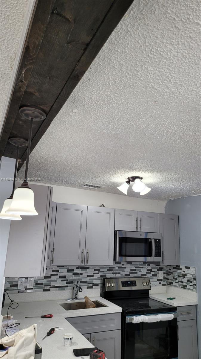 935 West 5th Street, Unit 935 Riviera Beach, FL 33404 - Photo 5 of 11 a kitchen with stainless steel appliances kitchen island granite countertop a sink dishwasher stove and oven