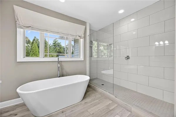 a white bath tub sitting in a bathroom next to a window