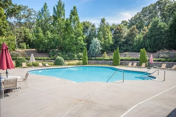 a view of swimming pool with seating area and trees around