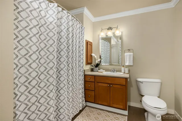 a bathroom with a toilet sink vanity and mirror