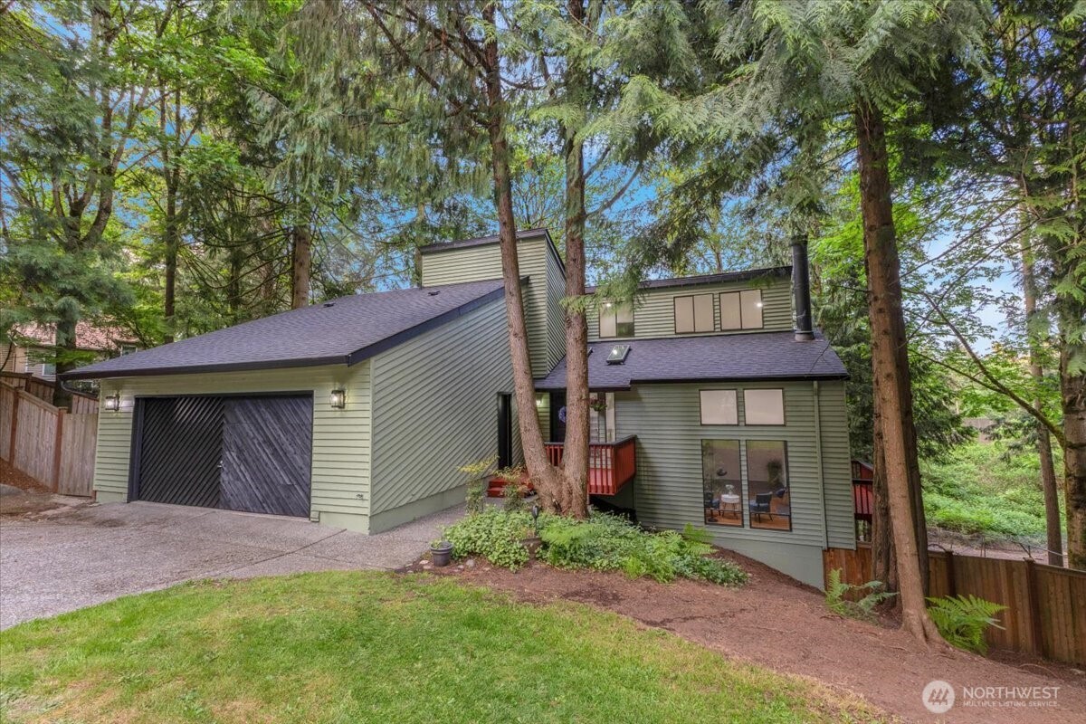 front view of a house with a yard and an trees