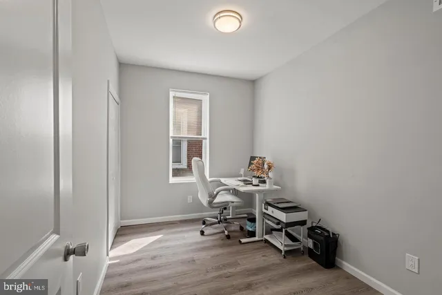 a workspace with wooden floor and a window