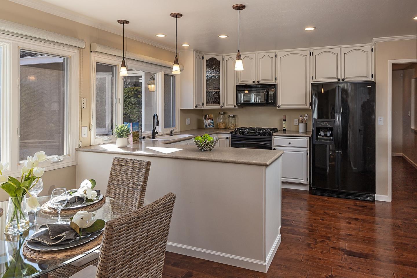 505 Preston Drive Mountain View, CA 94040 - Photo 9 of 23 a kitchen with stainless steel appliances granite countertop a refrigerator a stove a sink and a dining table with wooden floor