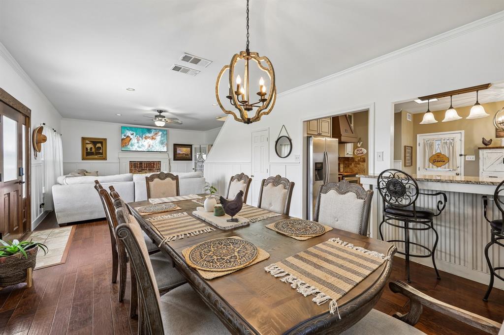 331 Radecke Road Krum, TX 76249 - Photo 13 of 40 Dining area featuring a wood-finish dining table and matching chairs, illuminated by a decorative chandelier