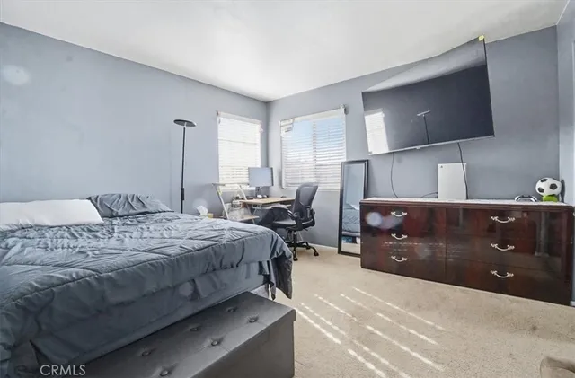 a bedroom with a bed and flat screen tv