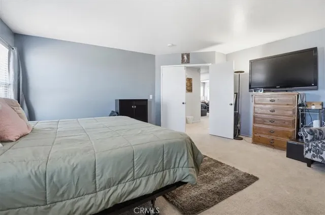 a bedroom with a bed and flat screen tv