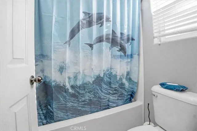 a bathroom with a granite countertop sink a toilet and shower