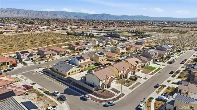 an aerial view of a city with lots of residential buildings and mountain view in back