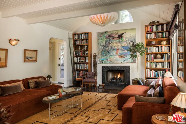a living room with furniture a fireplace and a large window
