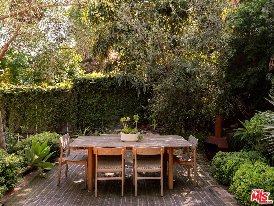 1452 Westerly Terrace Los Angeles, CA 90026 - Photo 28 of 39 a backyard with table and chairs with potted plants and large trees