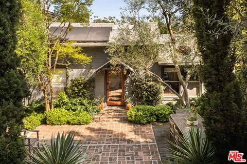 a view of a pathway of a house with a tree