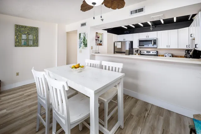 a view of kitchen with stainless steel appliances cabinets table and chairs