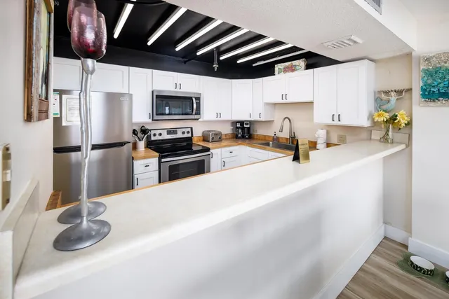 a kitchen with stainless steel appliances granite countertop a sink a stove and a refrigerator