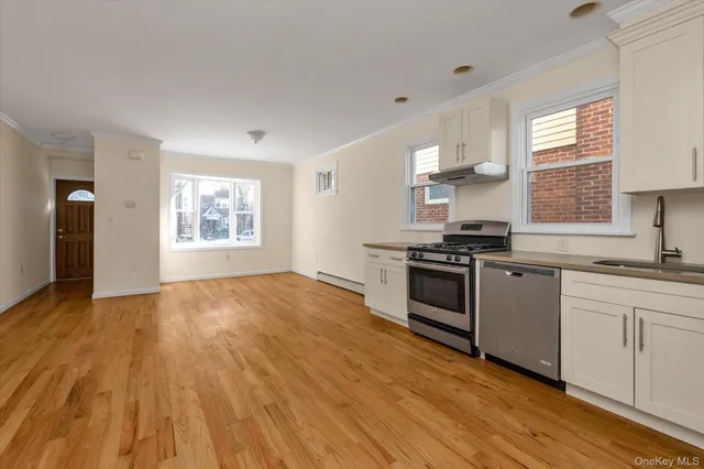 a kitchen with granite countertop a stove and a wooden floors