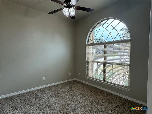 an empty room with a window and a chandelier