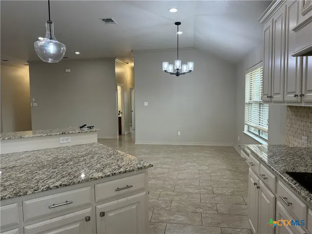 a view of a kitchen with a sink and chandelier