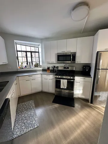 a kitchen with stainless steel appliances granite countertop a stove a sink and a refrigerator