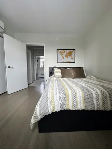 a bedroom with a bed and wooden floor