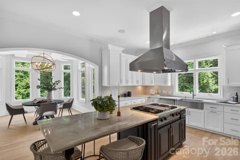 a kitchen with a table chairs a stove a sink and a window