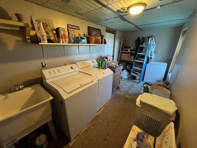 a utility room with dryer washer and a view of living room