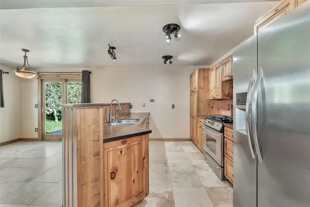 a kitchen with stainless steel appliances granite countertop a refrigerator and a sink