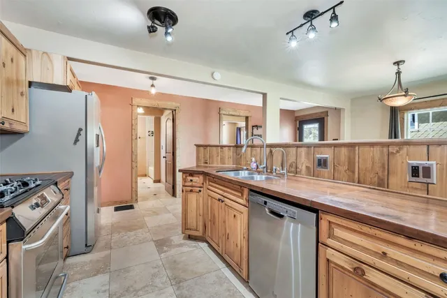 a kitchen with a sink refrigerator and cabinets