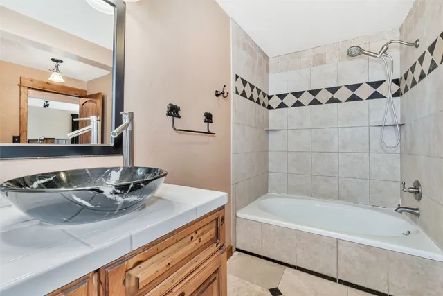 a bathroom with a tub sink and mirror