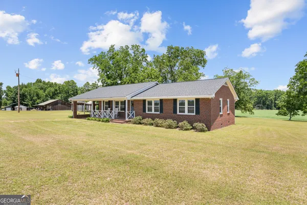 a front view of a house with yard and swimming pool