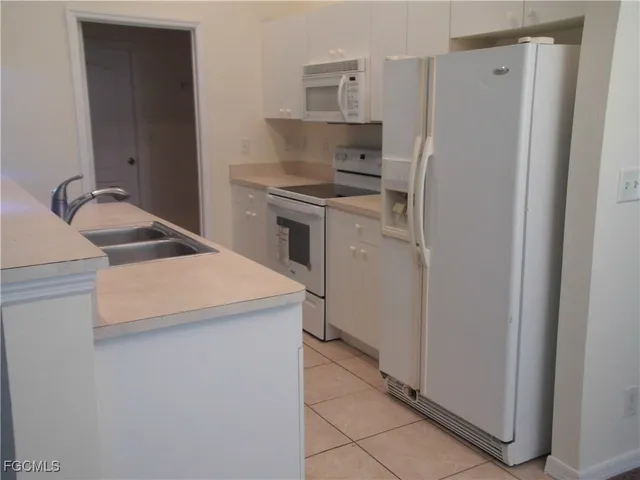 a kitchen with a refrigerator sink stove and cabinets