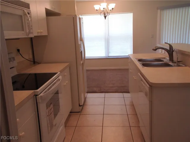 a kitchen with a sink a stove and cabinets