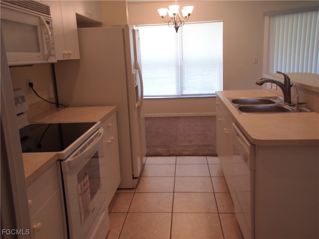 1117 Venetia Street Lehigh Acres, FL 33974 - Photo 5 of 10 a kitchen with a sink a stove and cabinets
