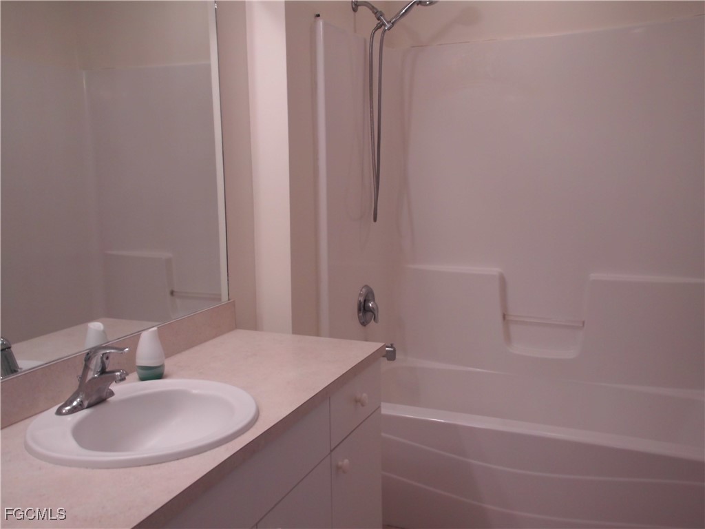 1117 Venetia Street Lehigh Acres, FL 33974 - Photo 7 of 10 a bathroom with a sink and a mirror