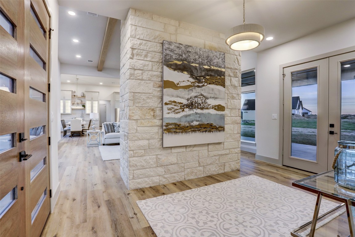 104 Turney Trace Round Top, TX 78954 - Photo 2 of 17 a view of a hallway with wooden floor and a living room