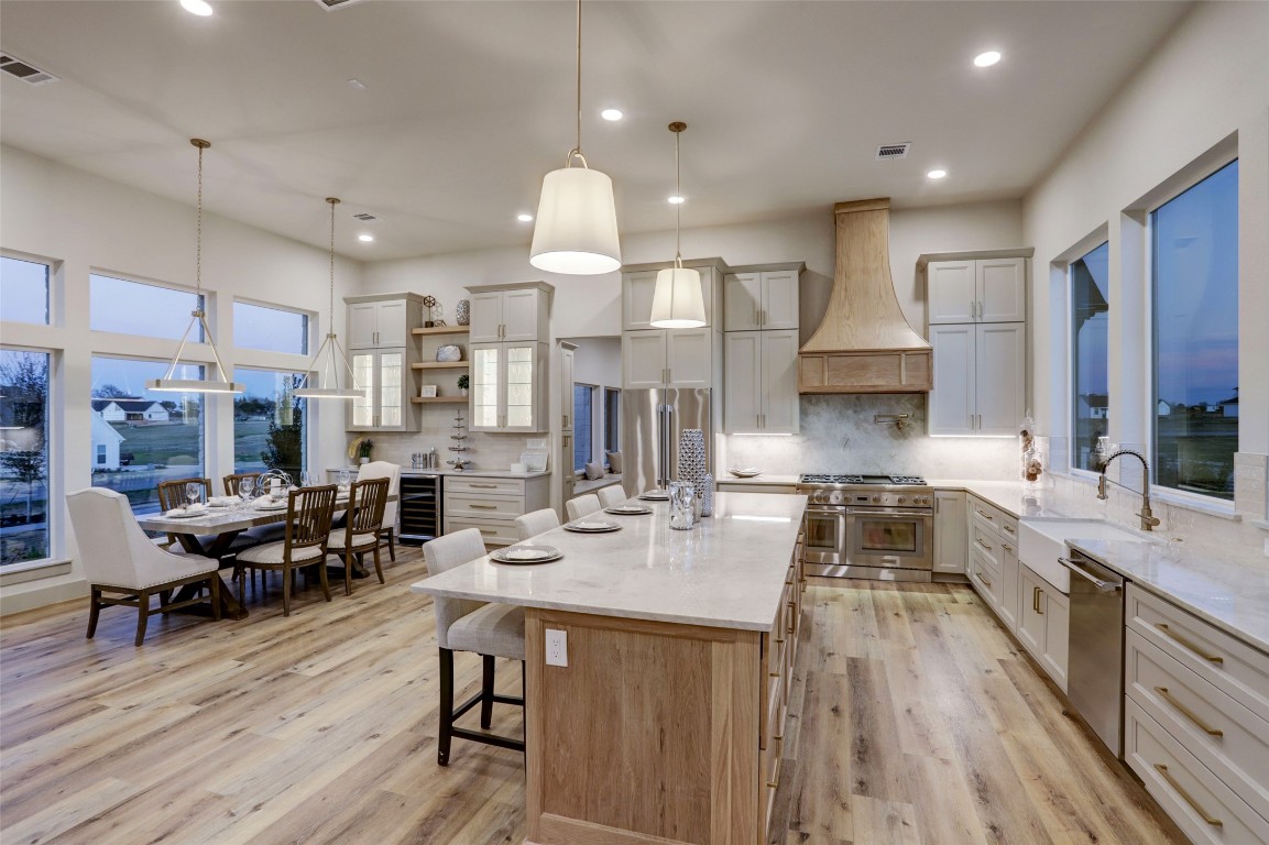 104 Turney Trace Round Top, TX 78954 - Photo 4 of 17 a large kitchen with lots of counter space dining table and stainless steel appliances