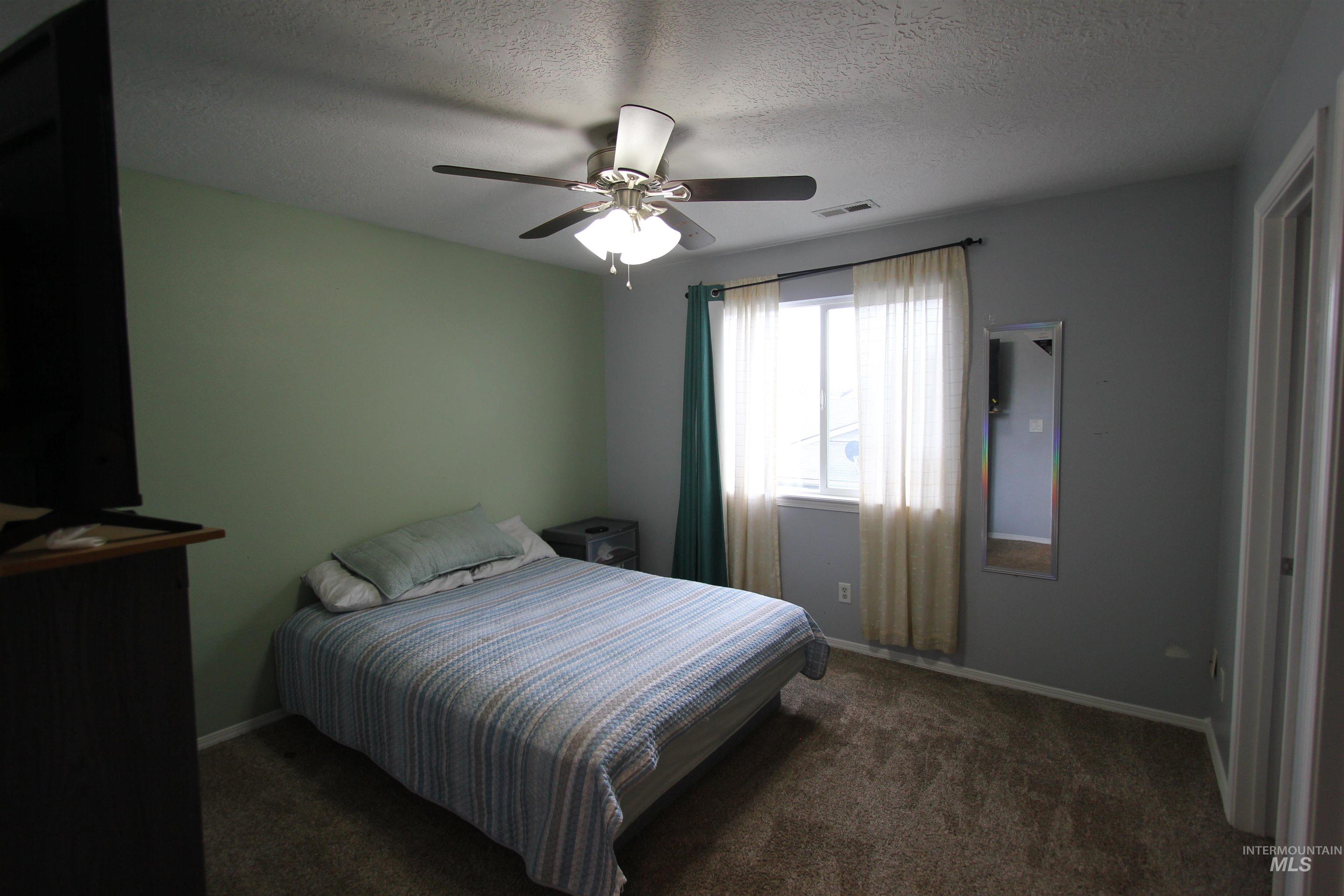 4816 Kadie Street Caldwell, ID 83607 - Photo 15 of 23 Bedroom featuring a window with natural light, a ceiling fan with integrated lighting, and carpeted flooring