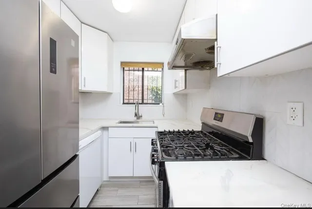 a kitchen with sink a microwave and cabinets