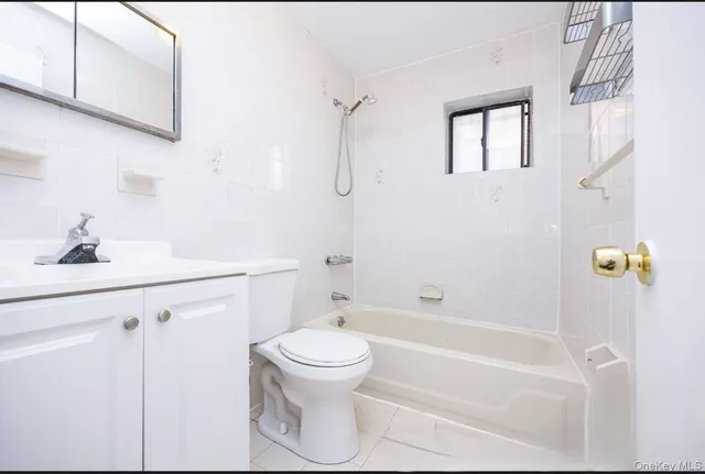 a bathroom with a bathtub shower sink vanity and toilet