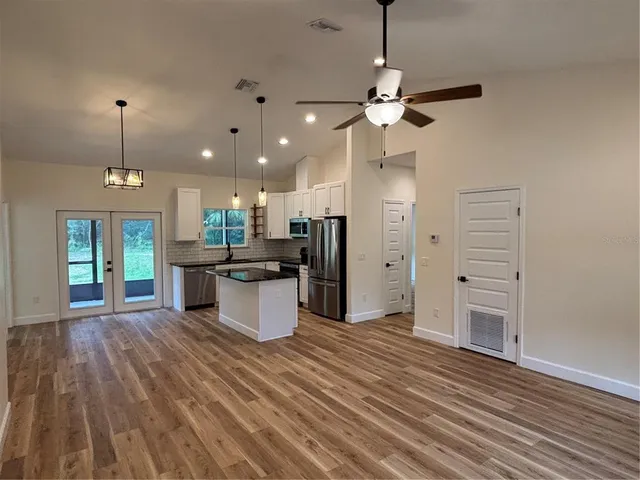 an open kitchen with refrigerator and microwave