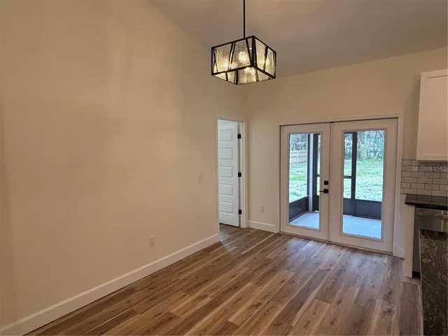 a view of a room with wooden floor and chandelier